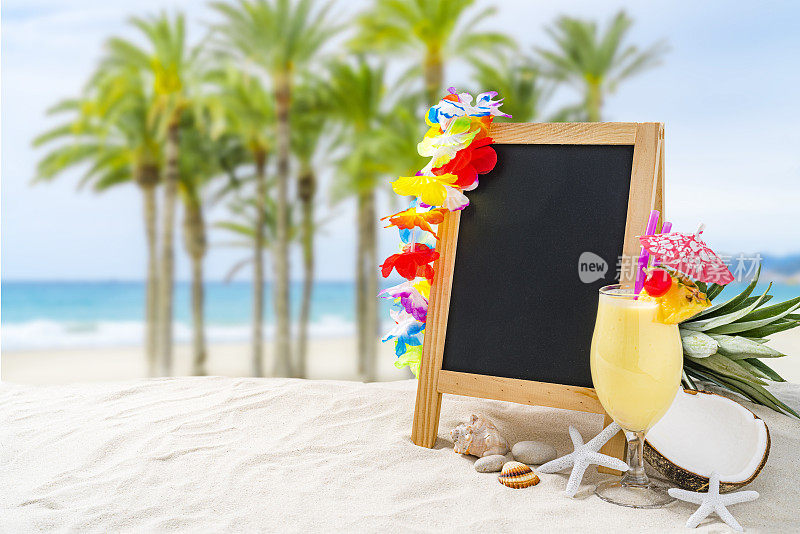 在Piña Colada玻璃的热带海滩上的空白黑板
